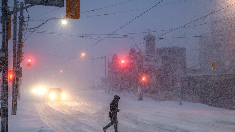 Gente camina por el centro de Toronto mientras una tormenta invernal pasa por la región, el...