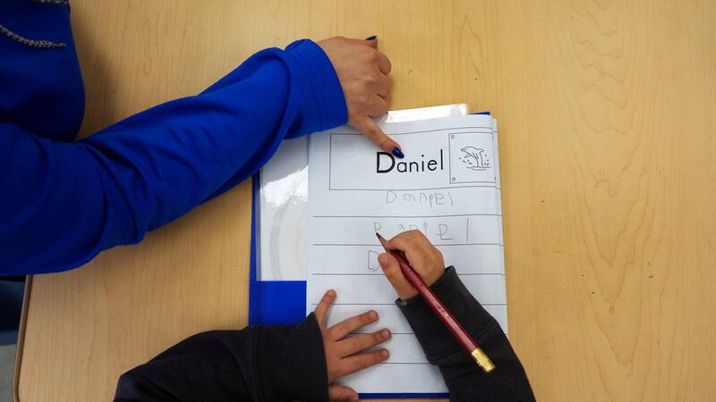 ARCHIVO - Tania Ortiz, maestra adjunta del programa Easterseals Head Start, ayuda a un niño a...