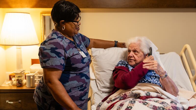 Jackie Conteh, cuidadora de adultos mayores originaria de Sierra Leona, visita a la residente...
