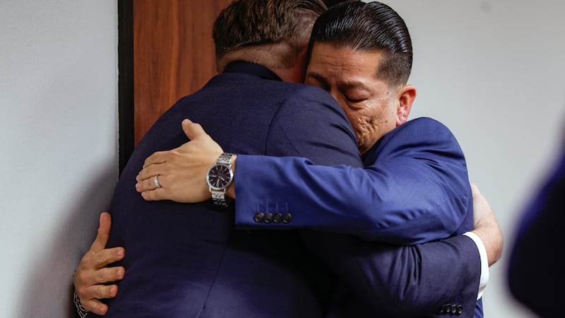 Adrian Gonzales (derecha), exagente de policía escolar de Uvalde, abraza a su abogado, Jason...