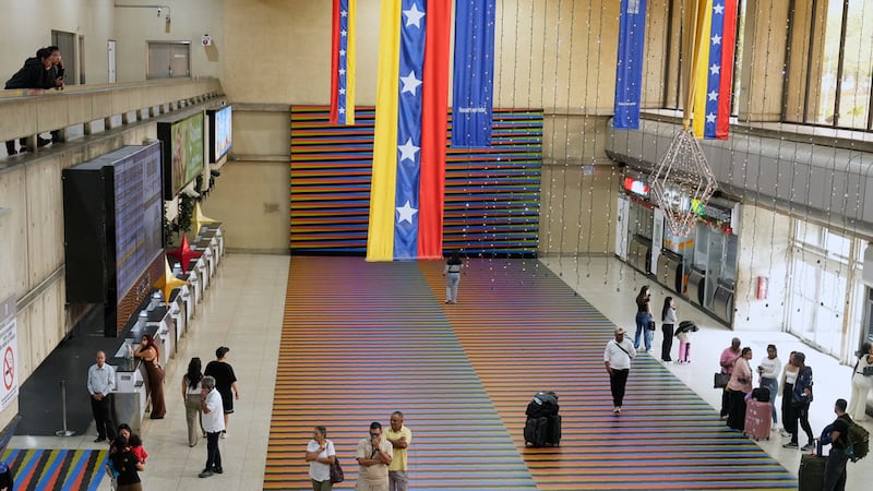 Un grupo de viajeros espera en la sala principal del Aeropuerto Internacional Simón Bolívar de...