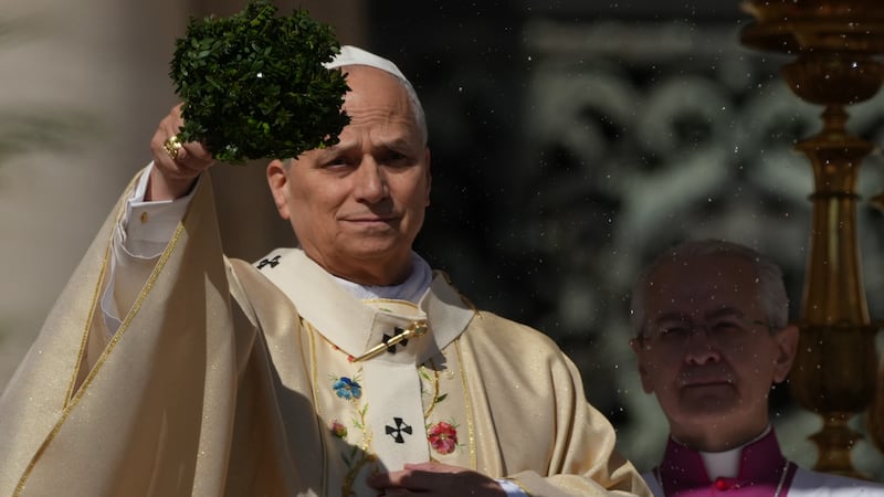 Pope Leo XIV sprinkles holy water with a bunch of hyssop sprigs as he presides over Easter...